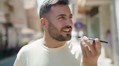 Genç İspanyol adam gülümsüyor. Kendine güveniyor. Sokakta akıllı telefondan konuşuyor.