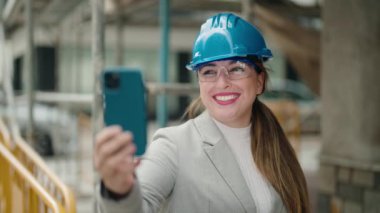 Genç bayan mimar caddede video görüşmesi yapıyor.
