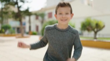 Blond child smiling confident dancing at park