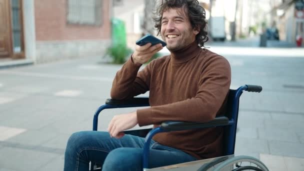 Молодой Латиноамериканец Разговаривает Смартфоне Сидя Инвалидной Коляске Улице — стоковое видео