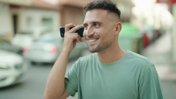 Молодий Іспаномовний Чоловік Посміхається Впевнено Слухаючи Аудіоповідомлення Смартфону Вулиці — стокове відео