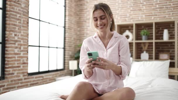 Ung Blond Kvinna Med Smartphone Sitter Sängen Sovrummet — Stockvideo