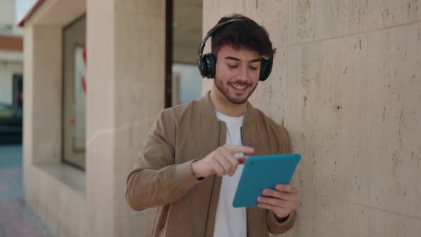 Jeune Homme Hispanique Souriant Confiant Utilisant Touchpad Écouteurs Rue — Video