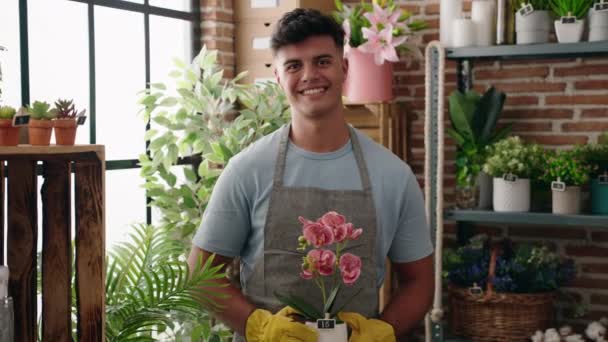 Joven Florista Hispano Sonriendo Confiado Sosteniendo Planta Floristería — Vídeos de Stock