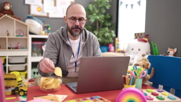 Jovem Careca Professor Pré Escolar Usando Laptop Comer Batatas Fritas — Vídeo de Stock