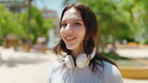 Młoda Kobieta Uśmiecha Się Pewnie Nosząc Słuchawki Parku — Wideo stockowe