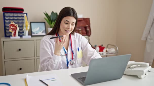 Young Beautiful Hispanic Woman Doctor Using Laptop Sending Voice Message — Stock Video