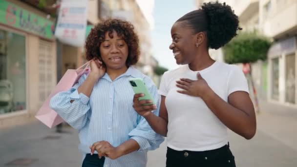 アフリカ系アメリカ人の女性の母親と娘が路上でショッピングバッグを持っている — ストック動画