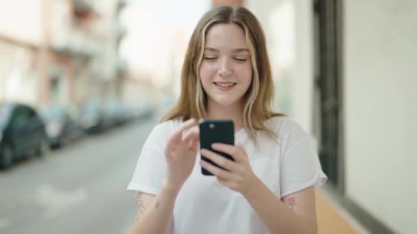 Junge Kaukasierin Lächelt Selbstbewusst Mit Smartphone Auf Der Straße — Stockvideo