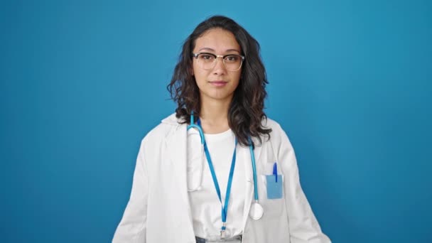 年轻美丽的惊慌失措的女医生 手托着胸膛在孤立的蓝墙背景下宣誓 — 图库视频影像