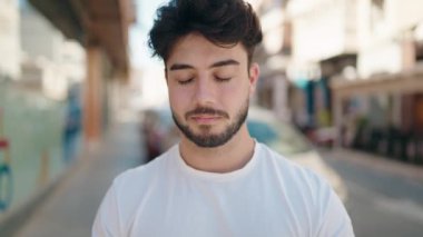 Sokakta kendinden emin gülümseyen İspanyol genç adam.