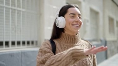 Sokak ortasında müzik dinleyen ve dans eden genç, güzel İspanyol kadın.