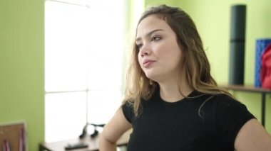 Genç, güzel İspanyol bir kadın spor merkezinde endişeli bir ifadeyle dikiliyor.