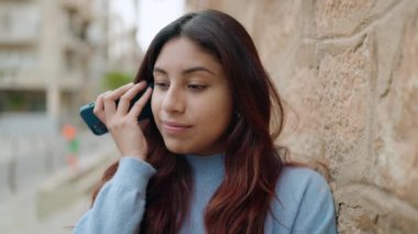 Genç İspanyol kadın gülümsüyor. Caddedeki akıllı telefondan kendine güvenen sesli mesaj dinliyor.