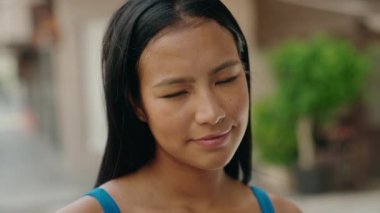 Sokakta kendine güvenen güzel Latin kadın gülümsüyor.