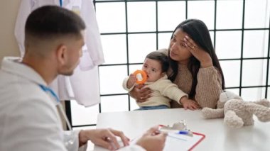 Çift ve oğul klinikte tıbbi danışmanlık yapıyorlar.