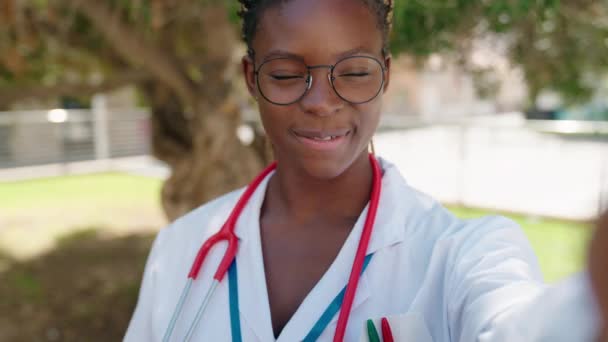 アフリカ系アメリカ人女性の医者は自信を持って笑ってビデオ通話を持って公園で — ストック動画
