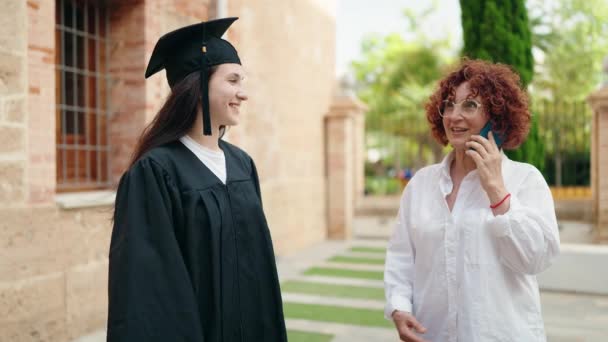 Two Women Mother Daughter Celebrating Graduation Talking Smartphone Campus University — Stock Video