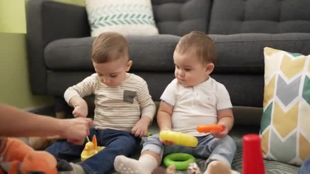 Två Bedårande Småbarn Leker Med Leksaker Som Sitter Golvet Hemma — Stockvideo