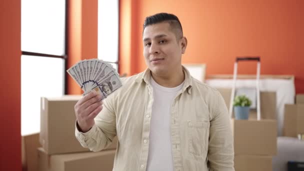 Jovem Hispânico Sorrindo Confiante Apontando Para Dinheiro Nova Casa — Vídeo de Stock