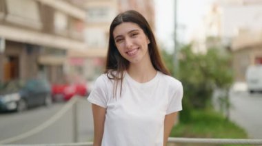 Genç İspanyol kız gülümsüyor. Kendine güveniyor. Öpüşme hareketi yapıyor.
