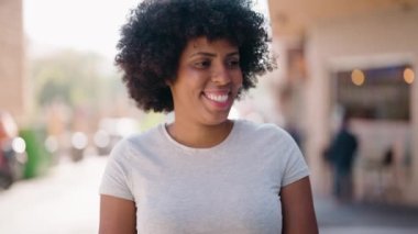 Genç Afrikalı Amerikalı kadın gülümsüyor. Kendine güveni tam.