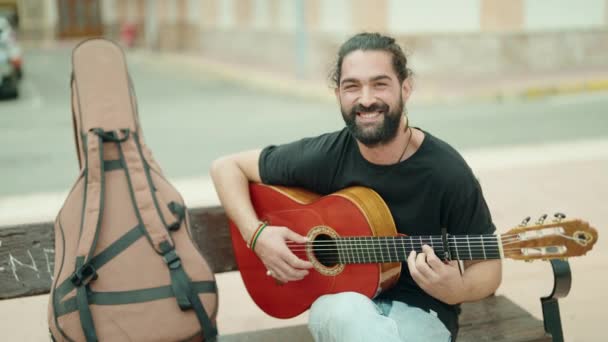 Молодой Латиноамериканец Играет Классической Гитаре Сидя Скамейке Улице — стоковое видео