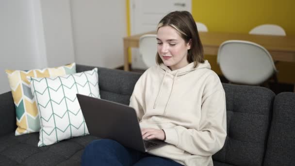 Junge Blonde Frau Sitzt Mit Laptop Auf Sofa Hause — Stockvideo