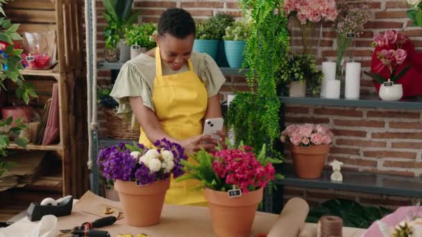 非洲裔美国女花匠在花店用智能手机拍照植树 — 图库视频影像