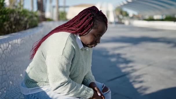 Αφρικανή Γυναίκα Πλεκτό Μαλλί Φαίνεται Λυπημένη Καθισμένη Ένα Παγκάκι Στο — Αρχείο Βίντεο