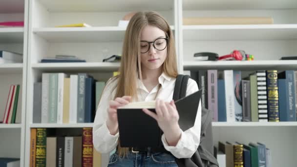 Young Blonde Woman Student Standing Reading Book University Classroom — Vídeo de Stock