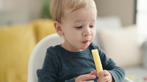 Adorable Niño Rubio Sentado Silla Alta Comiendo Bocadillo Casa — Vídeos de Stock