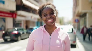 Afro-Amerikalı arkadaşlar gülümsüyor sokakta birbirlerine sarılıyorlar.