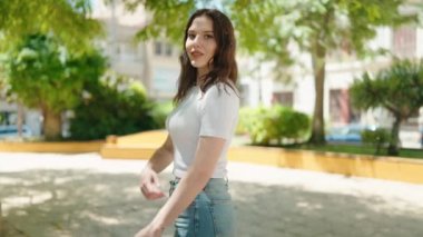 Young woman smiling confident standing with arms crossed gesture at park