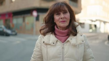 Middle age redhead woman smiling confident standing at street