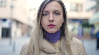 Sokakta yürürken rahat bir ifadeyle duran genç sarışın kadın.