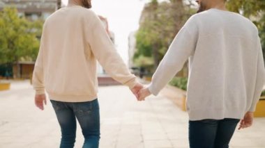 Young couple smiling confident hugging each other at park