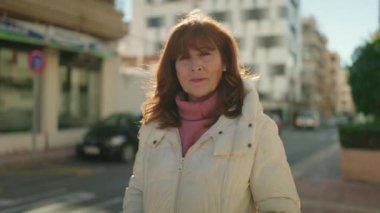 Middle age redhead woman smiling confident standing at street