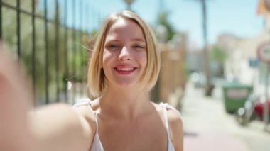 Genç sarışın kadın gülümsüyor. Kendine güveni tam.