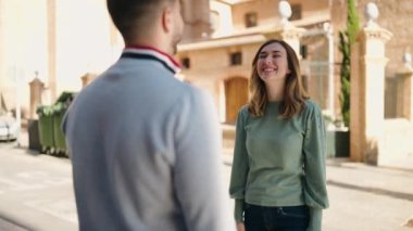 Young couple smiling confident hugging each other standing at street