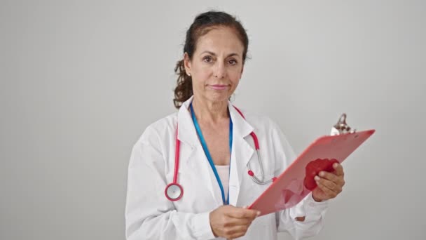 Μέση Ηλικία Ισπανόφωνη Γυναίκα Γιατρός Ανάγνωση Έγγραφο Στο Πρόχειρο Πάνω — Αρχείο Βίντεο