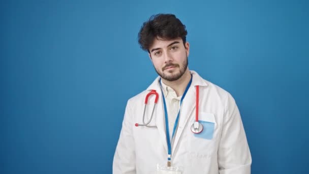 Jovem Hispânico Homem Médico Apresentando Sobre Fundo Azul Isolado — Vídeo de Stock