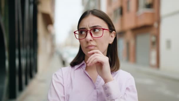 Młoda Latynoska Kobieta Okularach Stojąca Wątpliwym Wyrazem Twarzy Ulicy — Wideo stockowe