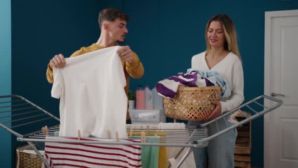 Young Couple Smiling Confident Hanging Clothes Clothesline Laundry Room — Vídeo de Stock