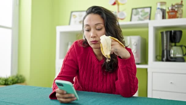Mladý Krásný Hispánec Žena Pomocí Smartphone Jíst Banán Jídelně — Stock video