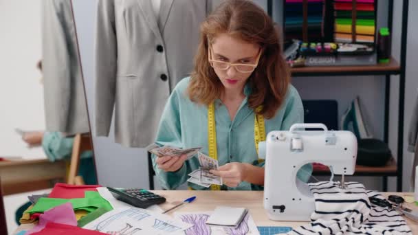 年轻美丽的惊慌失措的女人裁缝在裁缝店里数钱 — 图库视频影像