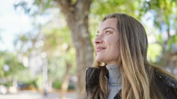 Νεαρή Καυκάσια Γυναίκα Χαμογελά Αυτοπεποίθηση Χρησιμοποιώντας Κιάλια Στο Πάρκο — Αρχείο Βίντεο