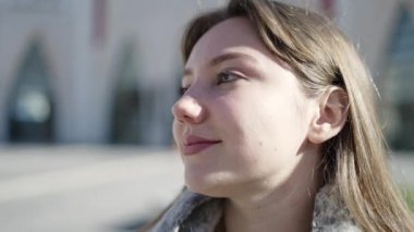 Young blonde woman smiling confident looking to the side at street