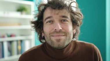Young hispanic man student smiling confident standing at library university