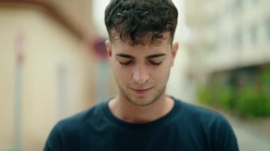 Sokakta ciddi bir ifadeyle duran İspanyol genç adam.